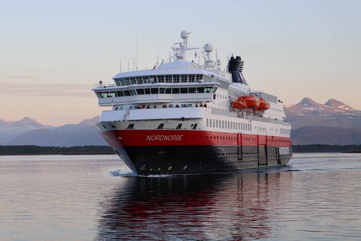 Die MS Nordnorge legt vor Molde an. Wie an einer Perlenschur aufgereiht recken sich 222 Berggipfel an der Südseite des Moldefjords entlang in die Höhe