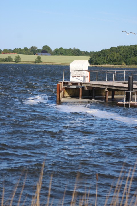 Ein Strandkorb bietet bei Wind guten Schutz – selbst auf einem Steg am Sportboothafen Lindaunis