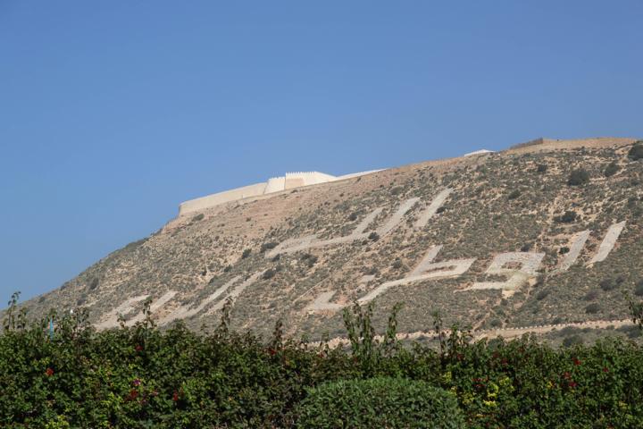 Die Ruinen der alten Kasbah mit den restaurierten Wällen liegen auf einem 236 Meter hohen Hügel mit dem Schriftzug (übersetzt) „Gott, Vaterland, König"