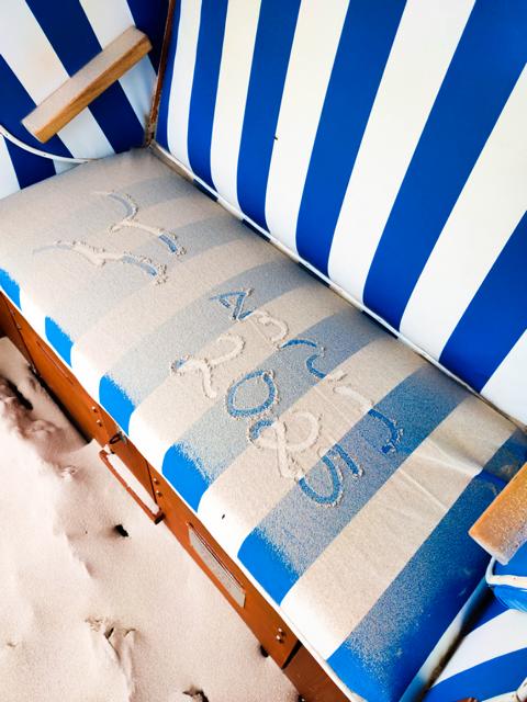 Und wenn es bisschen mehr weht, wird der feine Kniepsand als flüchtiger Schriftträger genutzt. Hier hat sich jemand mit „Amrum 2025“ auf der Sitzbank eines Strandkorbs ausgelassen