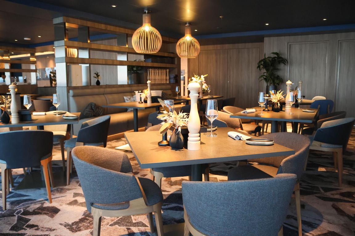 Warme Holztöne, dezente Beleuchtung und nordisches Design verleihen dem Restaurant Høfde auf Deck 16 der „Mein Schiff Relax“ eine elegante Atmosphäre