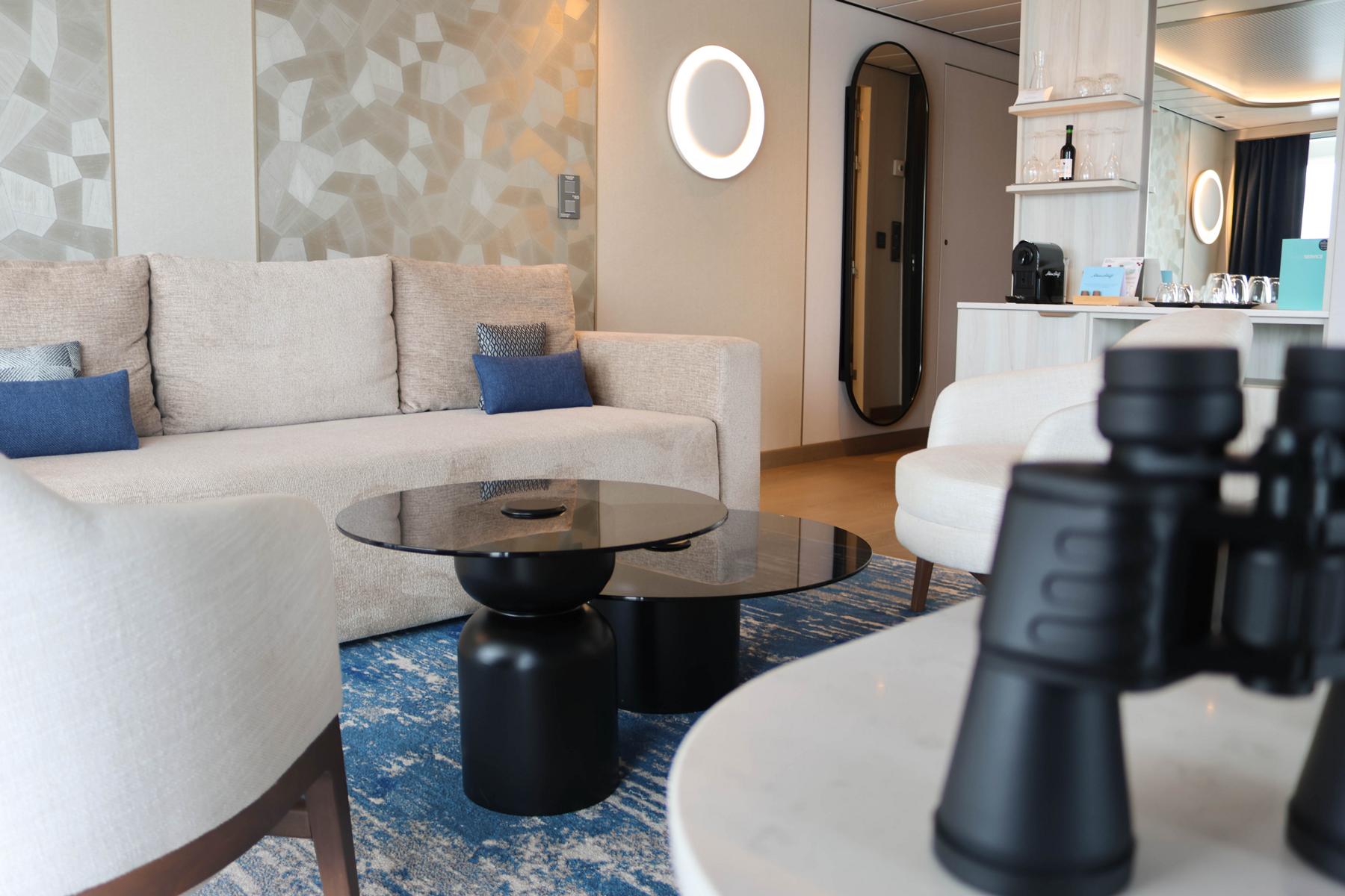 Der untere Bereich der Große Freiheit Suite auf der „Mein Schiff Relax“ (Eingangsebene auf Deck 9) bietet auf rund 44 m² ein luxuriöses Raumgefühl. Ein hochwertiges Fernglas gehört zur festen Premium-Ausstattung der Suiten