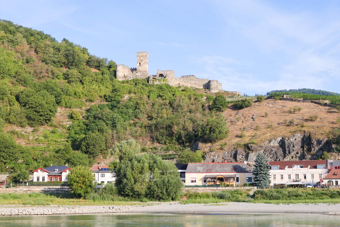 Die Burgruine Hinterhaus in Spitz überragt die steilen Hänge der Wachau. Wo sich normalerweise die tiefen, kraftvollen Fluten der Donau durch die Wachau drängen, zieht das Rekord-Niedrigwasser nun als schmales Band an Spitz vorbei