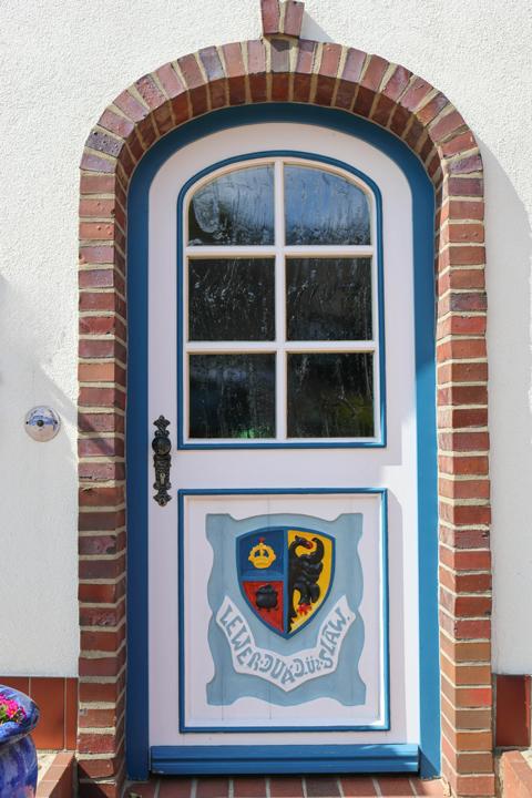 Nordfriesland Wappen auf der Eingangstür eines schmucken Friesenhauses: “ Lever duad üs Slaaw“ (lieber tot als Sklave) betont den sprichwörtlichen Unabhängigkeitssinn der Friesen
