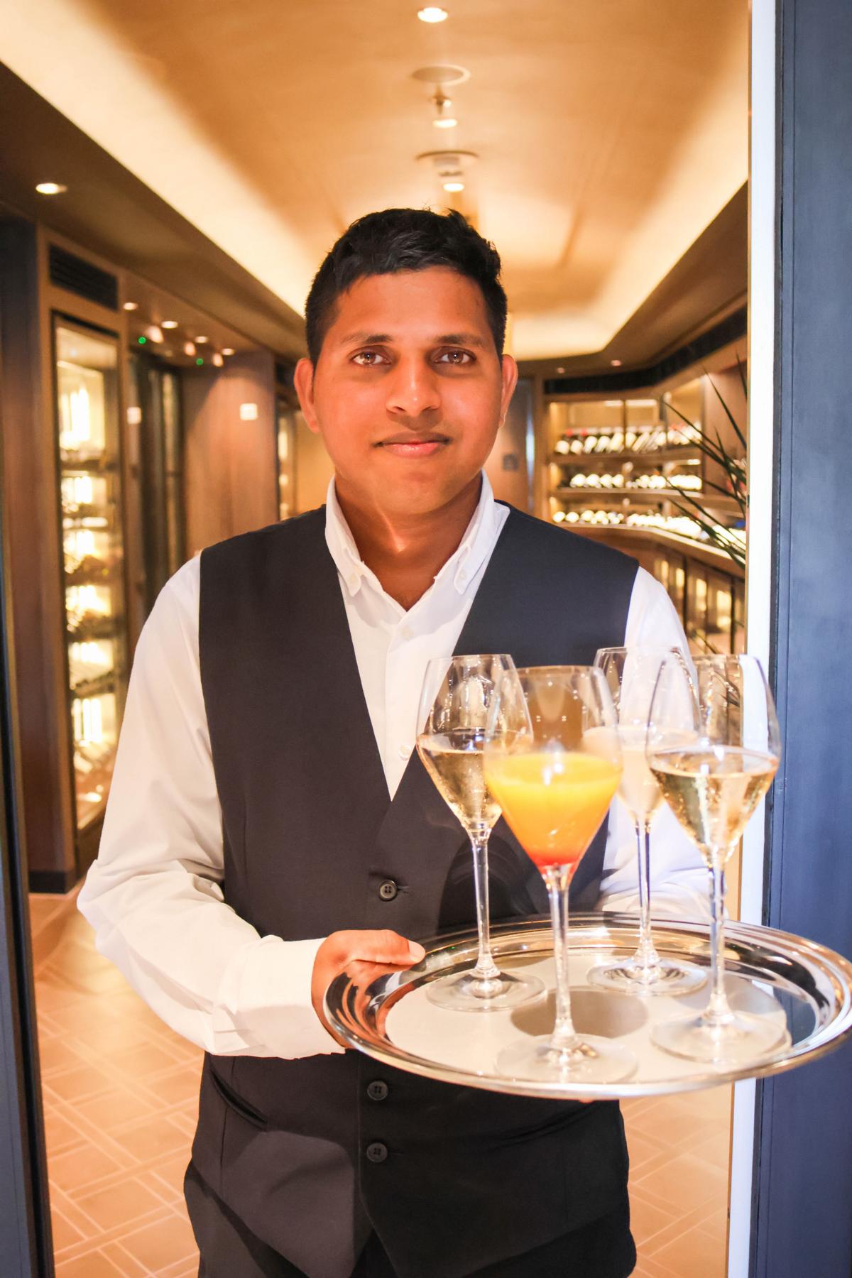 Vor „The Cellar“ empfängt ein Host die Gäste mit Champagner oder alkoholfreien Drinks. Dahinter wartet eine aufpreispflichtige Welt voller edler Tropfen