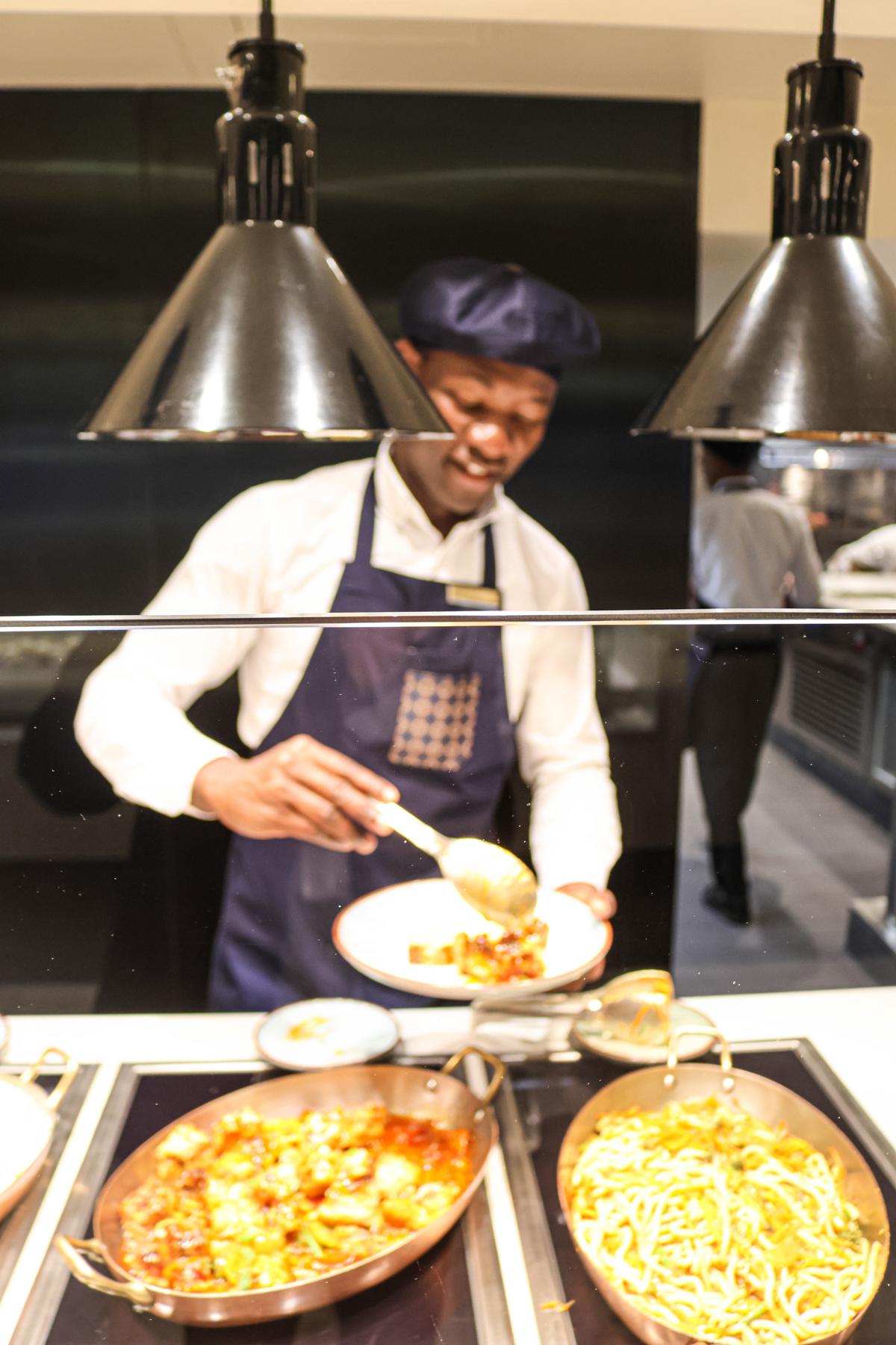 Im „Emporium Marketplace“ auf Deck 11 wählen die Gäste aus einer vielfältigen Auswahl internationaler Speisen. Doch statt sich wie in einem Buffetrestaurant üblich selbst zu bedienen, werden die gewünschten Gerichte an den einzelnen Stationen frisch angerichtet und serviert