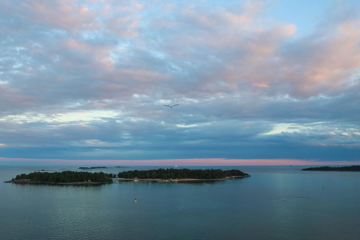 Zum Auslaufen aus Helsinki präsentiert sich die finnische Schärenwelt von ihrer schönsten Seite: Inseln, Wolken und das goldene Licht der Abendsonne begleiten die „Mein Schiff Relax“