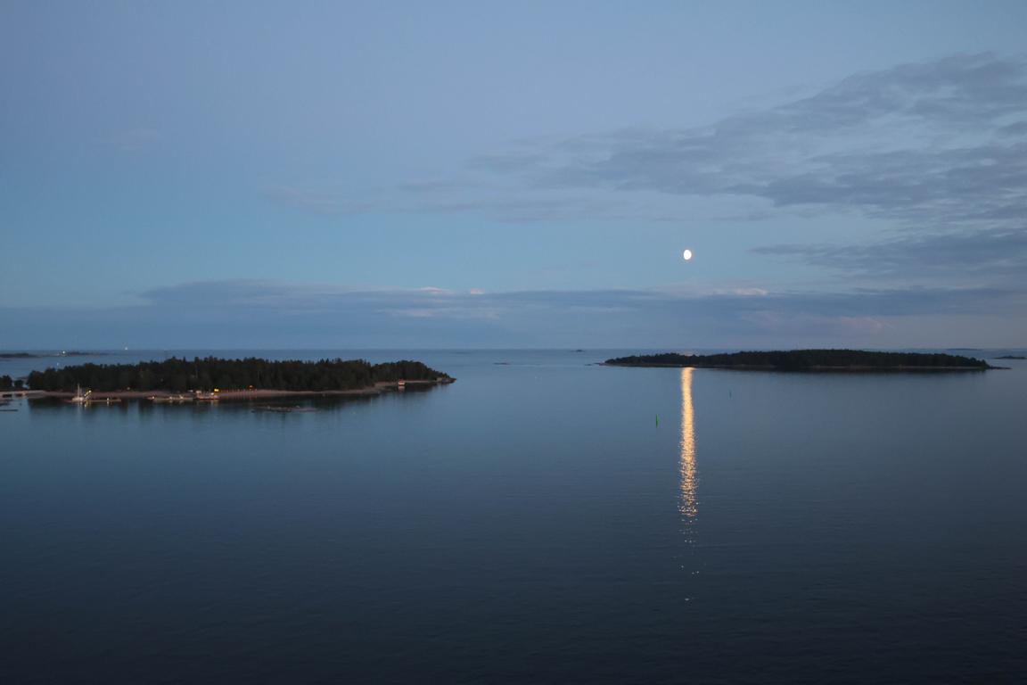 Zum Auslaufen aus Helsinki präsentiert sich die finnische Schärenwelt von ihrer schönsten Seite: Inseln, Wolken und das goldene Licht der Abendsonne begleiten die „Mein Schiff Relax“