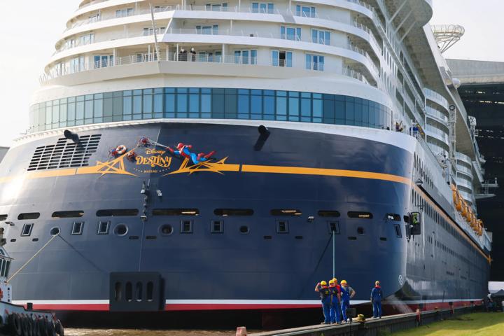 Die Disney Destiny verlässt mit Schlepperhilfe die Bauhalle der Meyer Werft. Ein Feuerwerk markiert den Baufortschritt des LNG-betriebenen Familienkreuzers für bis zu 4.000 Passagiere